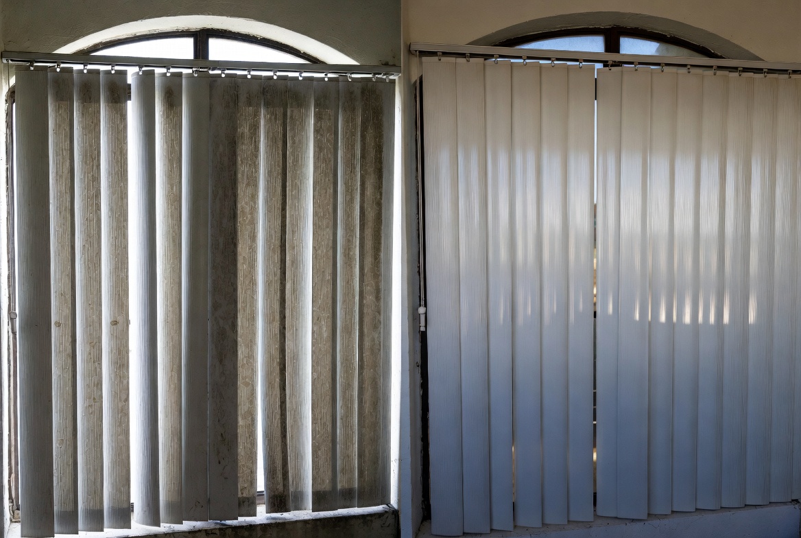 Commercial vertical blinds before and after cleaning — heavy dust and residue removed